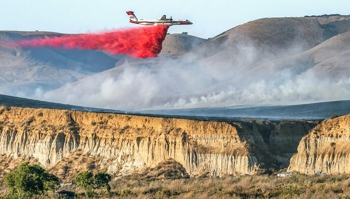 https://www.thenewlede.org/wp-content/uploads/2024/10/wildfire-suppressant-phos-chek-1024x683-1024x585.jpg